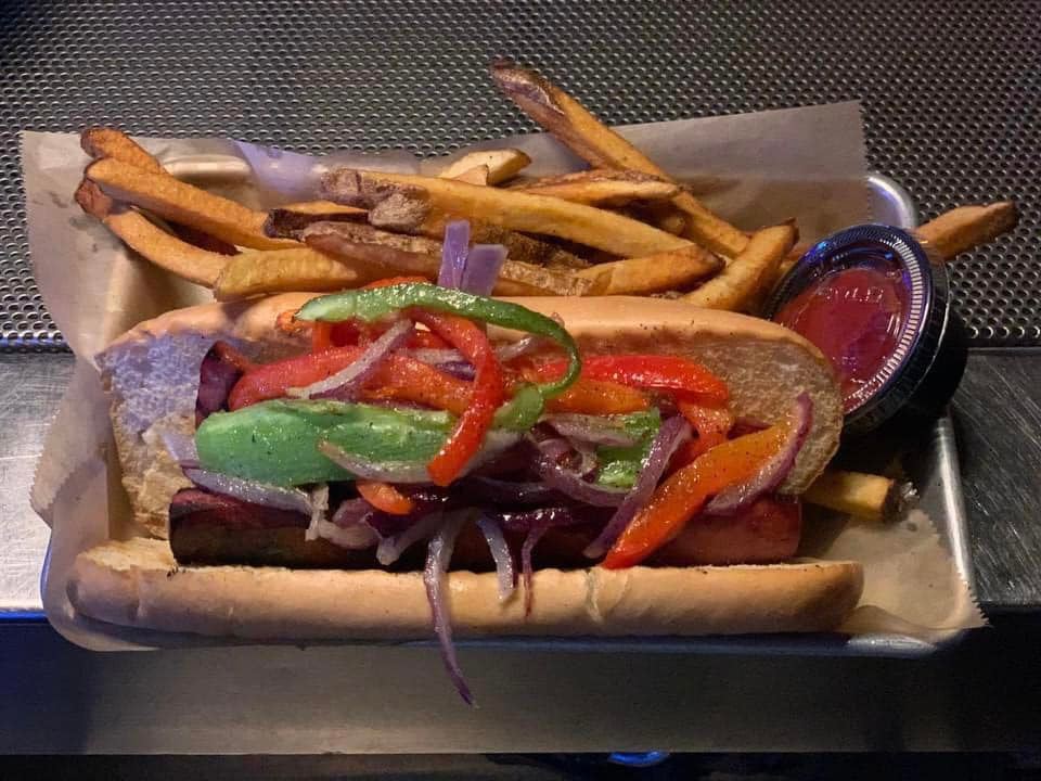 Hotdog with peppers and onions on top